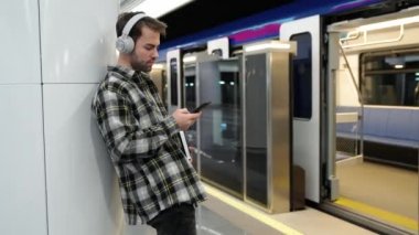 Genç bir öğrenci metroda tren bekliyor, akıllı telefon kullanıyor ve kablosuz kulaklıkla müzik dinliyor, bir öğrenci üniversiteye okumaya gidiyor, toplu taşıma araçlarıyla..