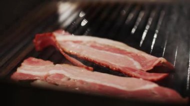 Hamburger malzemeleri, pişirme süreci ızgarada kızartılmış pastırma dilimleri, yemek festivali, 4k ağır çekim..