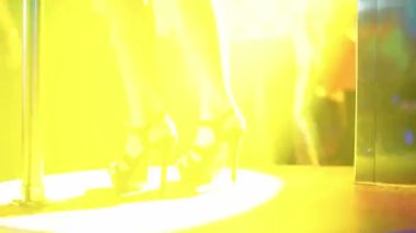 Gece hayatı, bir gece kulübünde eğlenmek ve dans etmek, çok renkli ışık, dans pistinde dans eden kadın, bacakların manzarası..