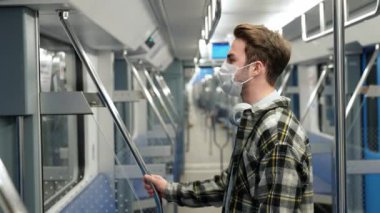 El bilgisayarı, maskeli genç adam metroya biniyor, öğrenci üniversiteye okumaya gidiyor, sabah toplu taşıma, virüs koruması, tecrit....