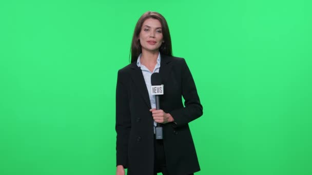 Kvinnlig Reporter Kostym Tittar Kameran Och Talar Mikrofon Grön Bakgrund — Stockvideo