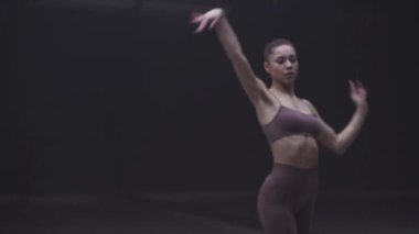 Sağlık, kadınlar karanlık bir odada yoga yapıyor, genç kadınlar yoga elementleri ve esneme hareketleriyle güzel bir dans sergiliyor..
