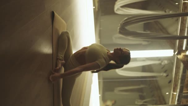 手持瑜伽 女人在镜室里做瑜伽 柔韧的女人表演伸展瑜伽元素 社交网络的垂直视频 — 图库视频影像