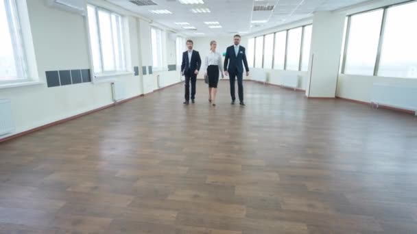 ビジネスミーティング トップマネージャーのチームが会うために歩いています パノラマウィンドウを持つ白いオフィススペースのインテリア 高層ビルの内側のオフィスを歩く — ストック動画