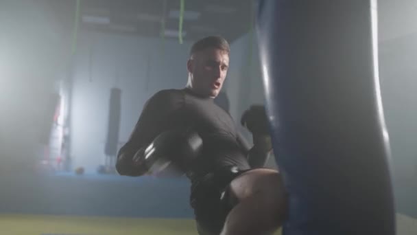 공격적인 전투기는 체육관에서 자신의 펀치를 선수는 가방을 슬로우 — 비디오