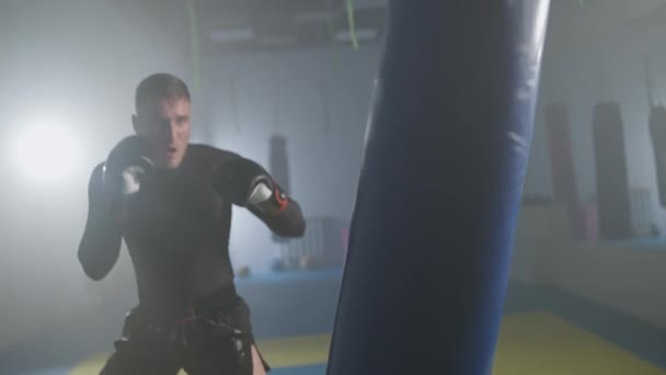 공격적인 전투기는 체육관에서 자신의 펀치를 선수는 가방을 슬로우 — 비디오