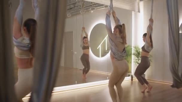 一群女性在镜室里做瑜伽 年轻女性用瑜伽元素表演美丽的舞蹈 在房间里用布线伸展舞蹈 — 图库视频影像