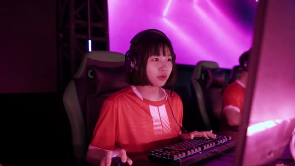 ヘッドフォンでアジアの女性ゲーマーの肖像画 ゲームでビデオゲーム サイバースポーツマン プレイヤー間のコミュニケーション チームとしてプレー — ストック動画