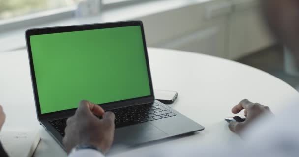 写字楼 第一人称视图 在带有绿色屏幕的笔记本电脑上工作的非洲商人 显示屏幕上的统计数据 协同工作 彩色键模板 — 图库视频影像