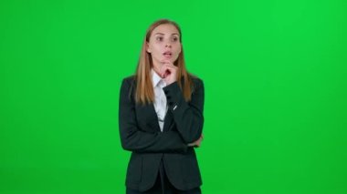 Sanat yönetmeni fikirler üretir, genç iş kadını yeni bir başlangıç için fikirler üretir, yeşil arka planda duran duygusal bir beyaz kadın, bir kroma anahtar şablonu.