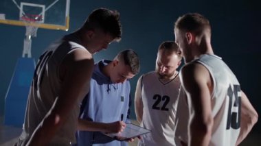 Basketbol şampiyonası, koç oyunculara oyunun taktiklerini öğretir, çizim için tablet ve işaret kullanır, maçtan önce brifing verir..