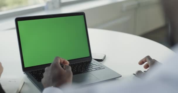 写字楼 第一人称视图 在带有绿色屏幕的笔记本电脑上工作的非洲商人 显示屏幕上的统计数据 协同工作 彩色键模板 — 图库视频影像