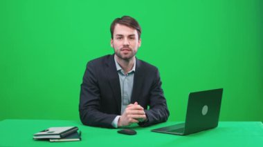 Muhabir stüdyoda oturuyor ve yeşil arka planda bir haber programı sunuyor, TV haber ajansları için bir şablon, iş yerinde bir gazeteci, kromakey.