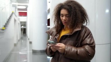Odaklanmış Afrikalı bir kadın metroda tren bekler ve akıllı telefon kullanır, internette sörf yapar, genç bir öğrenci üniversiteye okumaya gider, toplu taşıma araçlarıyla.