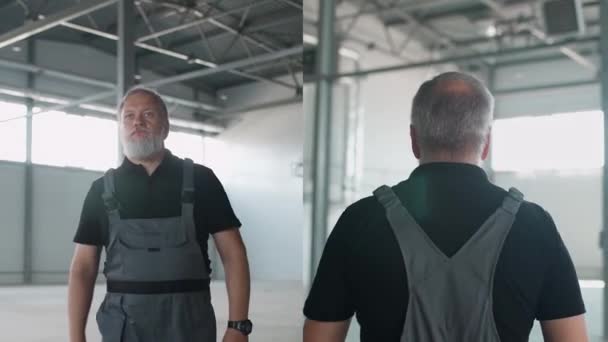 科拉奇 一个头发灰白的成年工人穿过仓库 一个工作的工程师穿过一个空旷的物流仓库 在屏幕上分叉 — 图库视频影像