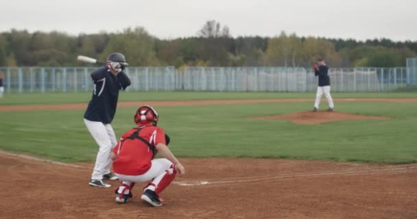 カレッジスポーツ 男たちは野球をする 投手はバッターに向かってボールを投げる 学校のスポーツ — ストック動画