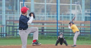 Yavaş çekim, okulda beyzbol turnuvası, beysbol oynayan çocuklar, atıcı topu vurucuya doğru fırlatıyor, vurucu başarılı bir şekilde hızlı topa vuruyor..