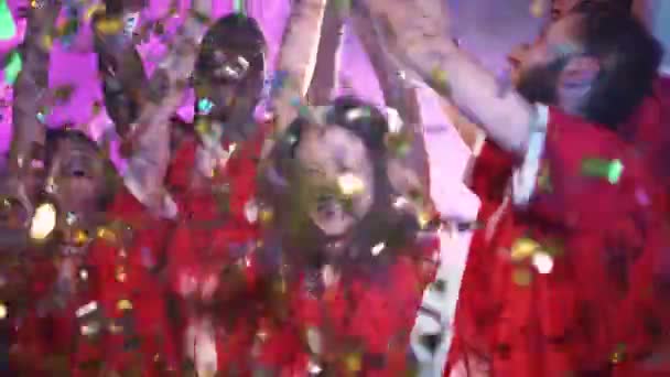 チームの勝利 Eスポーツ選手の赤いチームは 国際チャンピオンシップでの勝利に喜んで 女性は彼女の手で金のカップを保持しています Confettiは空中で飛んでいます — ストック動画