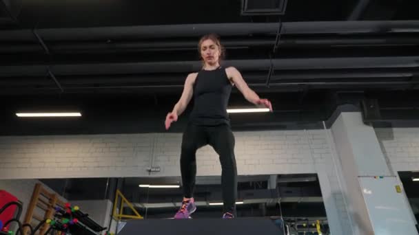 웰니스 스포츠 여성은 체육관에서 크로스 폭발적인 점프를 — 비디오