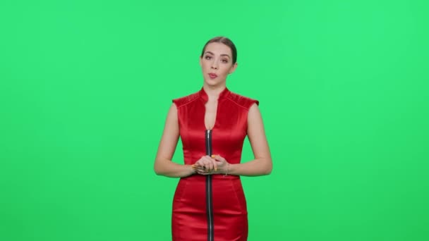 身着红衣服的年轻女性站在变色龙的背景下 看着摄像机 女演说家在电视演播室里为电视台制作模板 — 图库视频影像