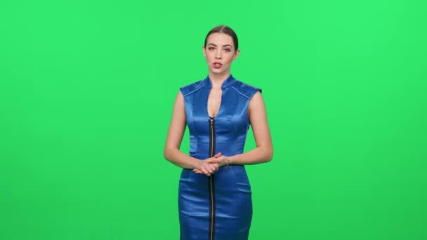 Woman Blue Dress Stands Green Background Looks Camera Female Speaker — Stock Video