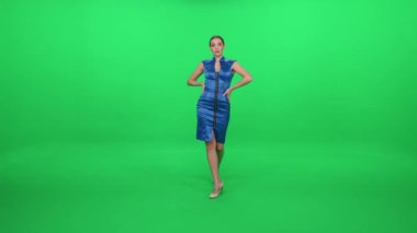 Yeşil arka planda yürüyen mavi elbiseli zarif bir kadın, bir kroma anahtar şablonu, poz veren kadın oyuncu..