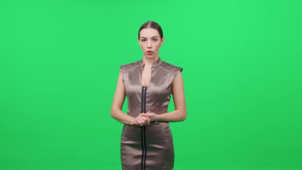 Mujer Presentadora Televisión Vestido Marrón Levanta Contra Fondo Verde Mira — Vídeos de Stock