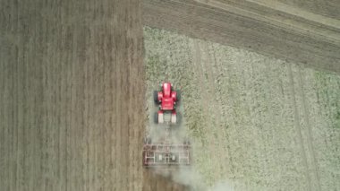 Tarım, tarım traktörü tarlada toprağı sürme, tarlada toz, yükseklikten manzara, tahıl ekme.