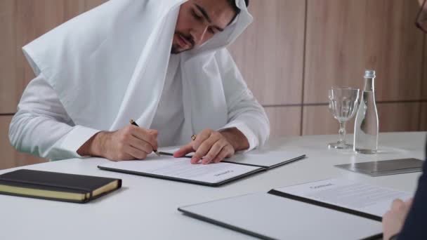 Арабський Чоловік Підписує Контрактні Документи Партнером Бізнесменом Костюмі Сидячи Офісі — стокове відео