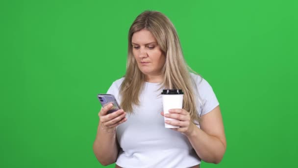 Woman White Shirt Standing Chromakey Background Using Smartphone Drinks Coffee — Stock Video