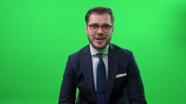 Zarif bir adamın portresi, TV sunucusu kameraya bakar ve konuşur, video ile iletişim, yeşil arka plan.