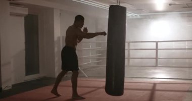 Kickboks, atletik adam dövüşçü trenleri tekmeler, kontur ışığı, boks salonunda antrenman günü..