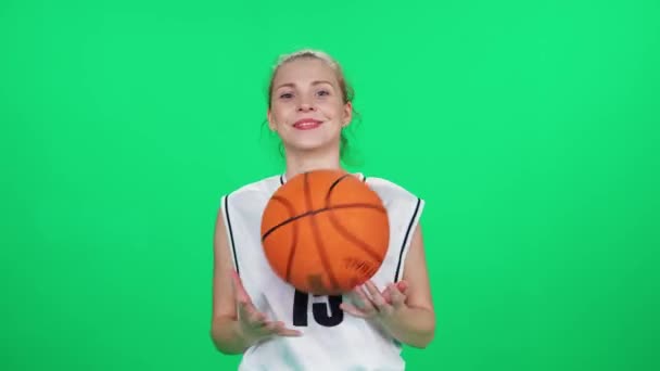 篮球运动员把球扔在手上 职业篮球运动员把球扔在室内操场上 绿色背景 — 图库视频影像