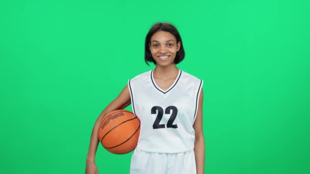 铁匠手上拿着球 室内操场上的职业篮球手 绿色的背景 那是一个快乐的深色皮肤的女人 — 图库视频影像