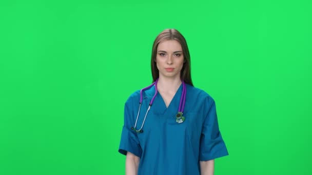 医护人员 女护士的肖像 漂亮的女人看着相机笑了 一个绿色背景的年轻实习生 铬钥匙模板 — 图库视频影像
