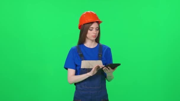 制服を着た若い女性労働者の肖像画 テクニカルエンジニアが立って緑の背景にスクリーンタブレットを使用し 染色体の女性エンジニア — ストック動画