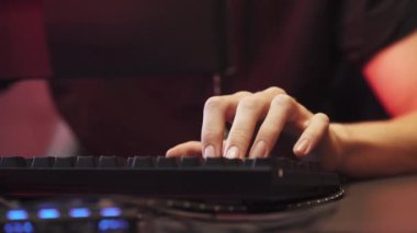 Genç oyuncu bir video oyunu oynuyor, elleri klavyeye yakın plan, siber sporcu.