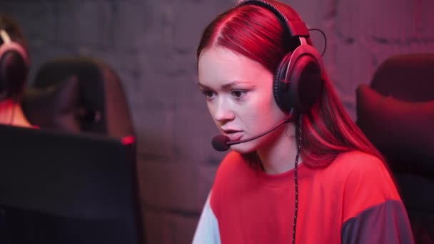 年轻的女玩家拿着耳机 玩电子游戏 网络游戏中的运动员 玩家之间的交流 — 图库视频影像