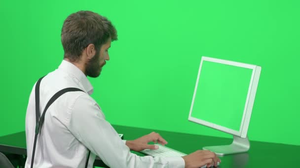 Desenvolvedor Software Focado Trabalhando Enquanto Sentado Uma Mesa Fundo Verde — Vídeo de Stock