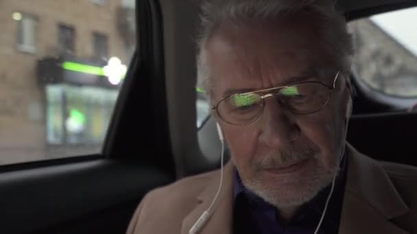 一位专心致志的建筑师 带着眼镜 凝视着笔记本电脑屏幕的灰白头发设计师的肖像 在移动的车上从事该项目的工作 — 图库视频影像