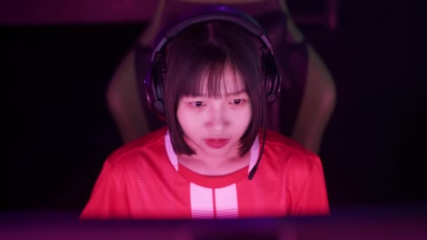 ハンドヘルド ヘッドフォンでアジアの女性ゲーマーの肖像画 ゲームでビデオゲーム サイバースポーツマン プレイヤー間のコミュニケーション チームとしてプレー トーナメント — ストック動画