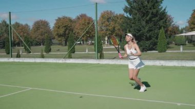 Genç bayan profesyonel tenisçi raketle topa vuruyor, tenis kortunda antrenman yapıyor, rakiplerine vuruyor tenis maçında servis yapıyor, 4k süper yavaş çekim..