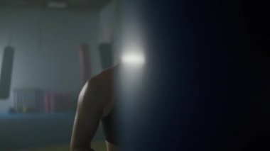 Kadın boksör antrenörleri yumruk atıyor, kum torbasını dövüyor boks salonunda antrenman yapıyor, kadın sert vuruyor, sağ kroşe..