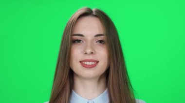 Neşeli beyaz bir kadının portresi kameraya bakar ve gülümser, yeşil arka plan, kromakey.