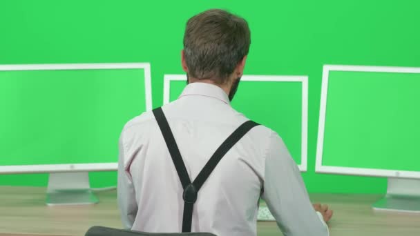 Konzentrierter Journalist Der Arbeitet Während Schreibtisch Sitzt Grüner Hintergrund Ein — Stockvideo