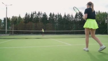 Kadın tenisçinin arka planı raketle topa vuruyor, kadın tenis maçında rakiplerine vuruyor, aktif oyun.