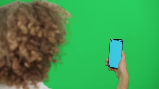 Молодой Человек Использует Смартфон Прокручивает Изображения Пролистывает Зеленый Экран Синий — стоковое видео