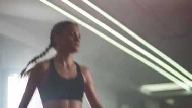Kadın boksör ısınıyor ve boks salonunda antrenman yapmadan önce zıplıyor..