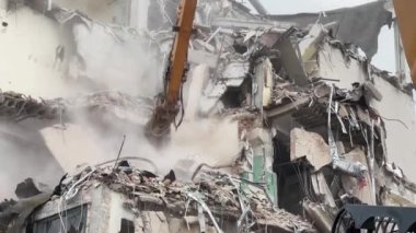 Doğal afetler, yerleşim alanındaki bir binanın yıkılması, depremden sonra binayı yıkan hidrolik kazıcı pençesi..