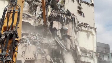 Depremin artçı sarsıntıları, yerleşim alanındaki bir binanın yıkılması, endüstriyel ekipmanların yardımıyla molozların sökülmesi..